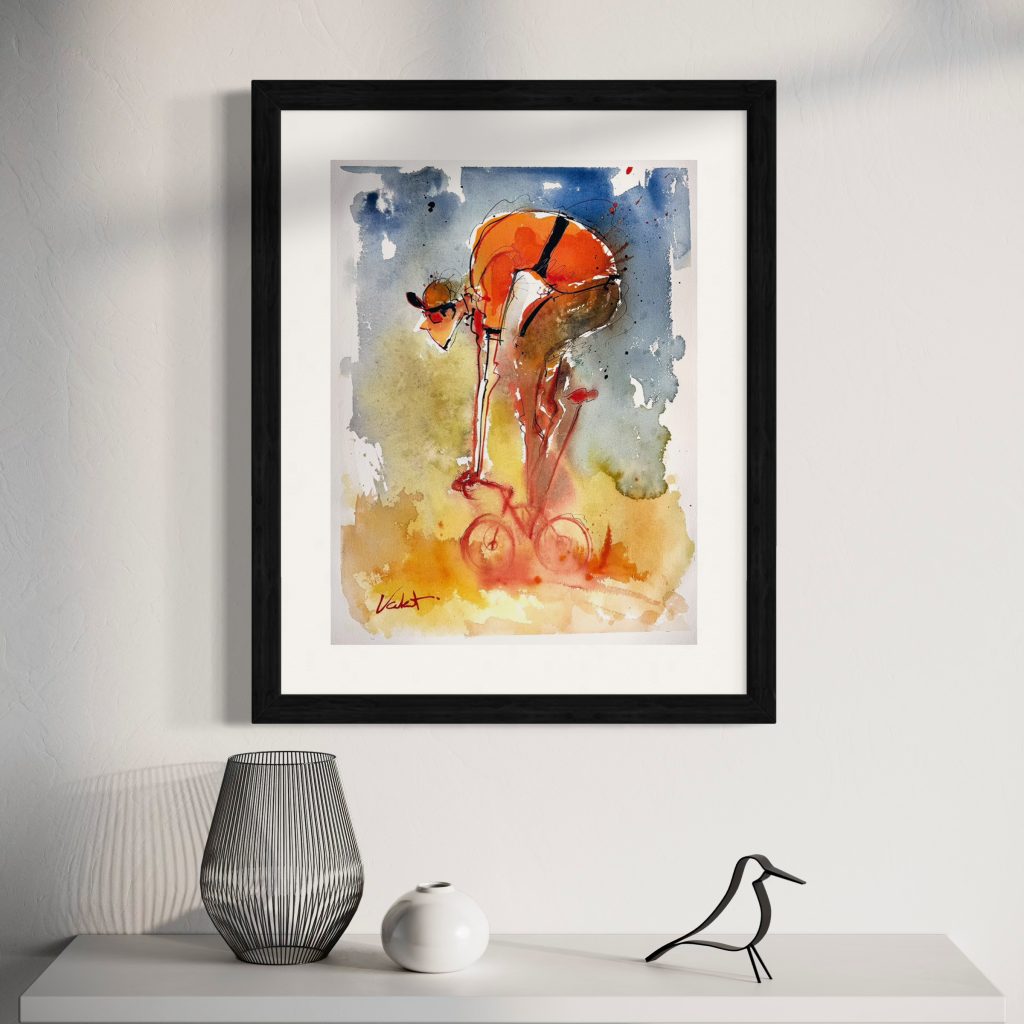 Rider Orange_framed sq - Michael Valenti Framed abstract painting with blue and orange watercolor on a white wall above a white table, flanked by decorative objects like a black wire vase and white sphere